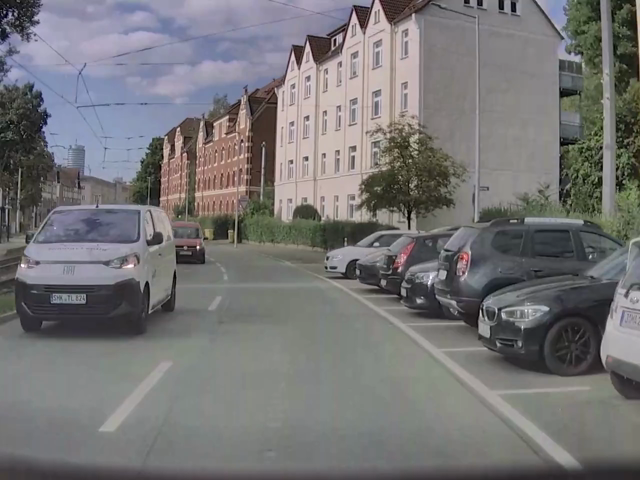 Ein Auto drängelt sich mit minimalem Abstand an einem Fahrrad vorbei.